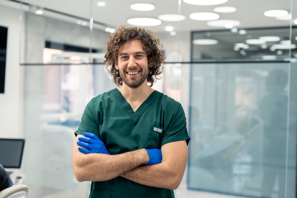 A male nurse at a nurses' station in a clinical setting
