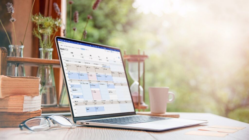 Laptop open to a calendar on a sunlit desk, marking the September 30 deadline to enroll in student loan auto pay.
